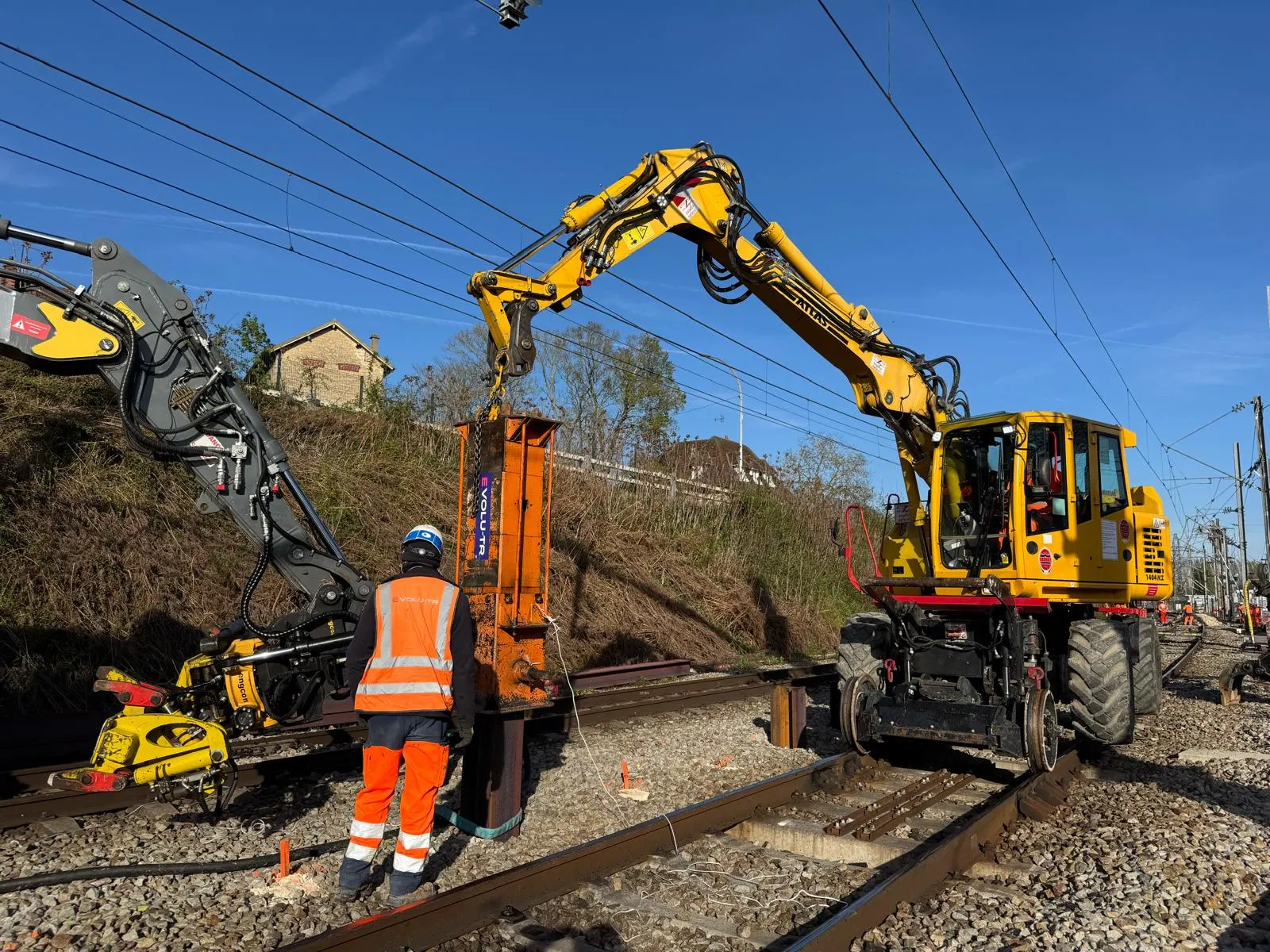 Battage en voie depuis une pelle rail-route, sous caténaires.